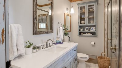 Rustikales Badezimmer mit weißen Armaturen und blauen, gealterten Holzschränken