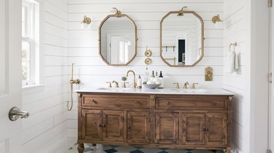 Bauernhaus-Badezimmer mit weißen Shiplap-Wänden, vintage Messingarmaturen und einem antiken Waschtisch