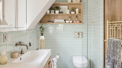 Kleines Badezimmer mit pastellgrünen Fliesen und Elementen aus natürlichem Holz.