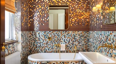 Badezimmer im Art-Deco-Stil mit bunten Mosaikfliesen und goldenen Armaturen