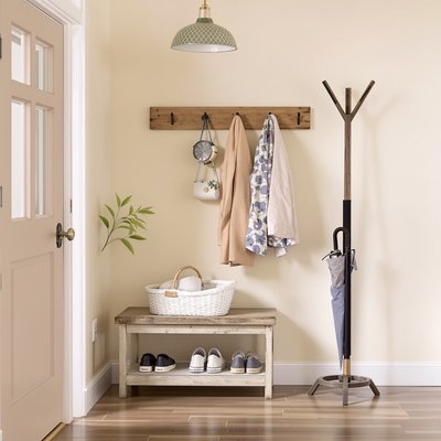 Pastellfarbener Eingangsbereich mit einem rustikalen Schuhregal, Garderobenständer und Regenschirmhalter.