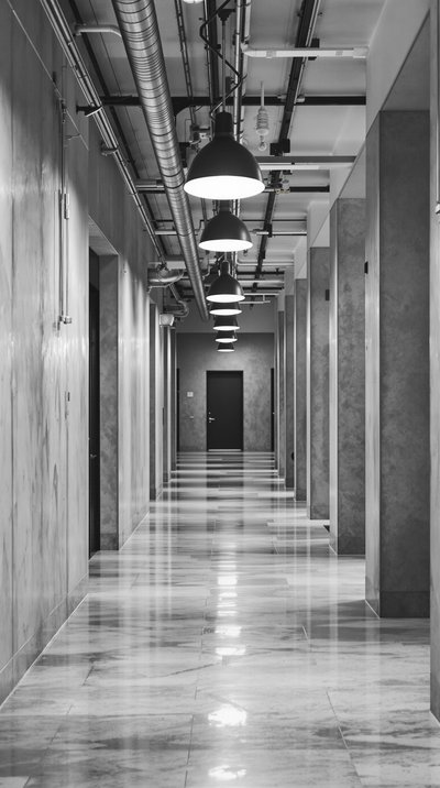Minimalistischer Industrieflur mit poliertem Betonboden und hängenden Pendelleuchten