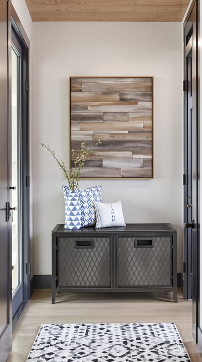 Moderner Flur im Industriedesign, mit einer Metall-Aufbewahrungsbank und rustikaler Kunst