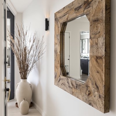 Moderner Flur im Bauernhausstil mit Spiegel aus wiederverwendetem Holz und Tongefäßvase.