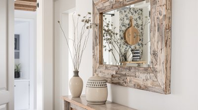Moderner Flur im Bauernhausstil mit Spiegel aus wiederverwendetem Holz und Tongefäßvase.