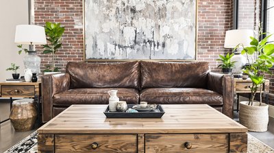 Wohnzimmer im Industriestil mit abgenutztem Ledersofa und Couchtisch aus wiederverwendetem Holz