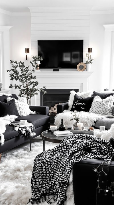 Gemütliches monochromes Wohnzimmer mit weißen Kunstfell-Texturen und schwarzen Möbeln